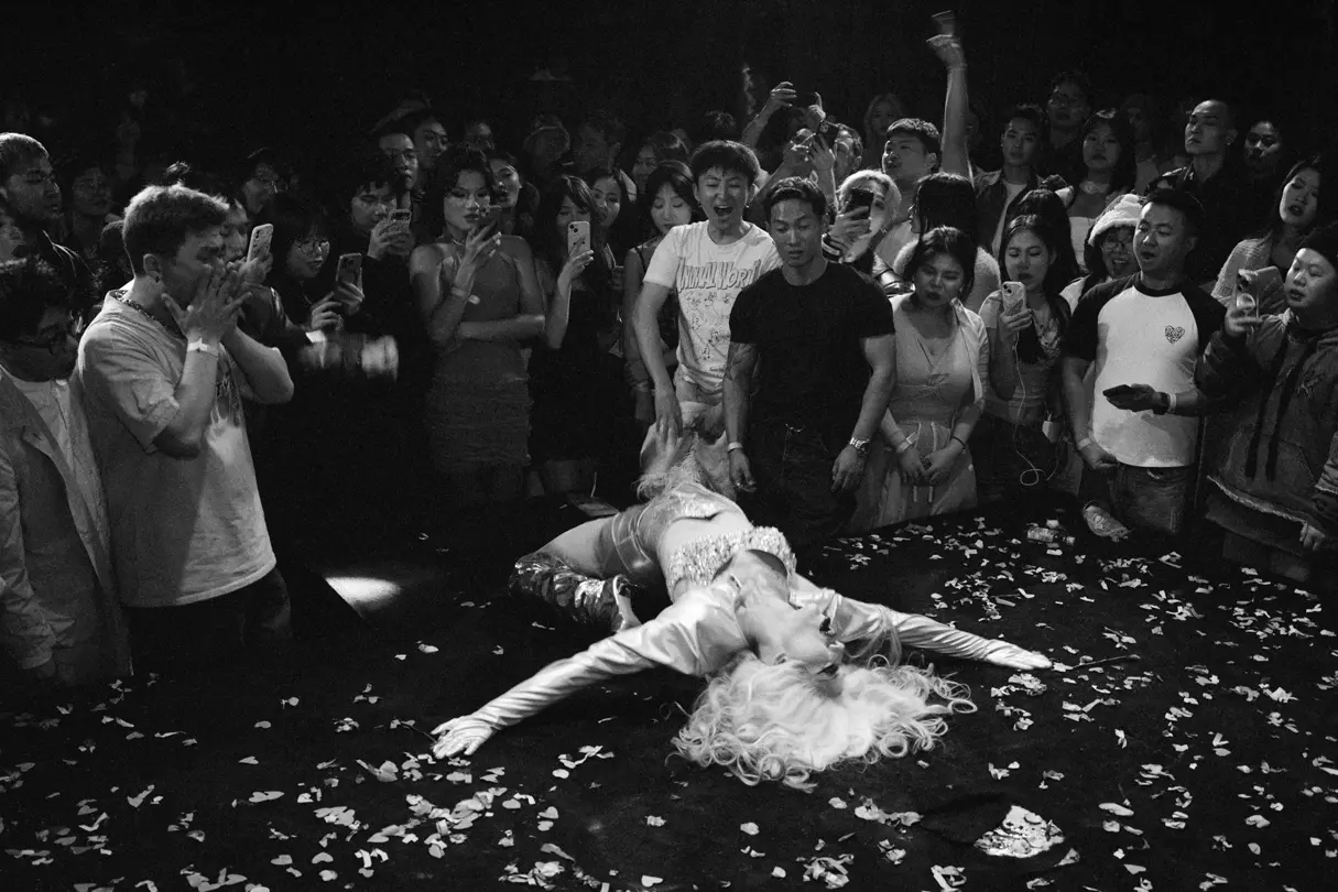 A woman on the table watched by many people.