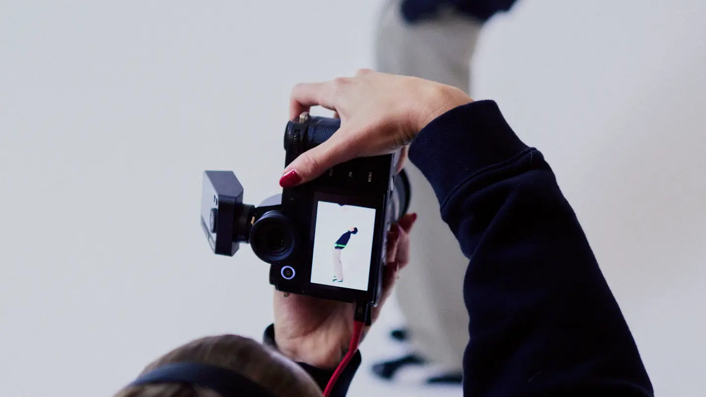 Photographer from behind in a photo studio photographing a man