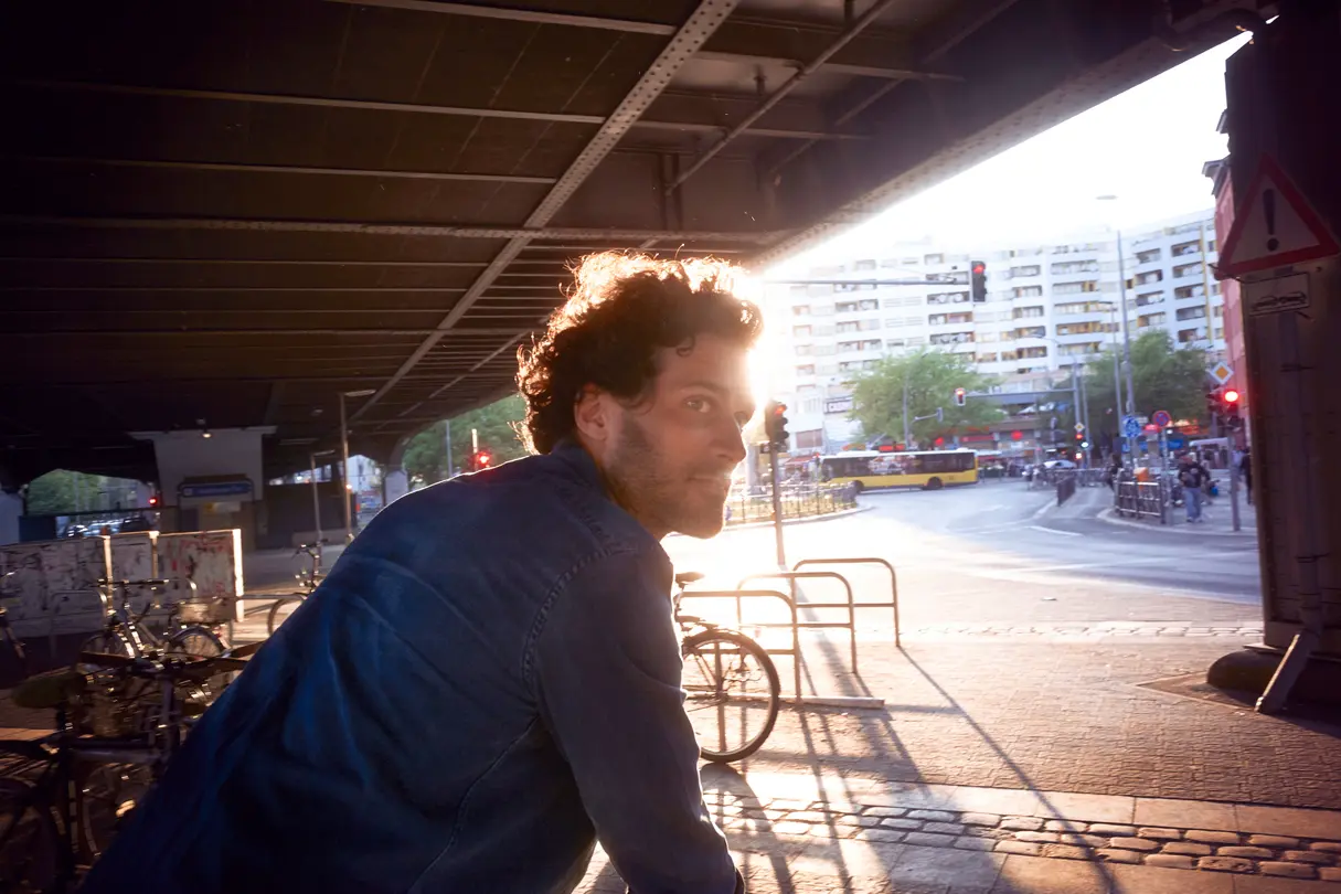 A man stands on a bicycle parking space and looks into the city.