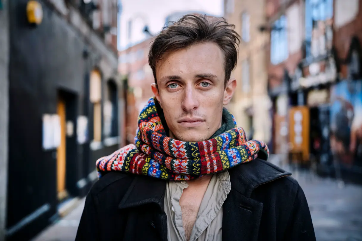 A man with a scarf in a city