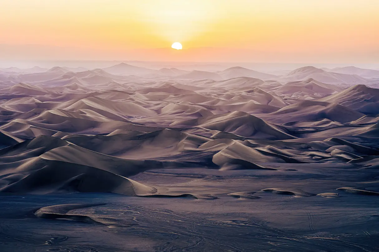 Sun on the horizon in a mountainous landscape