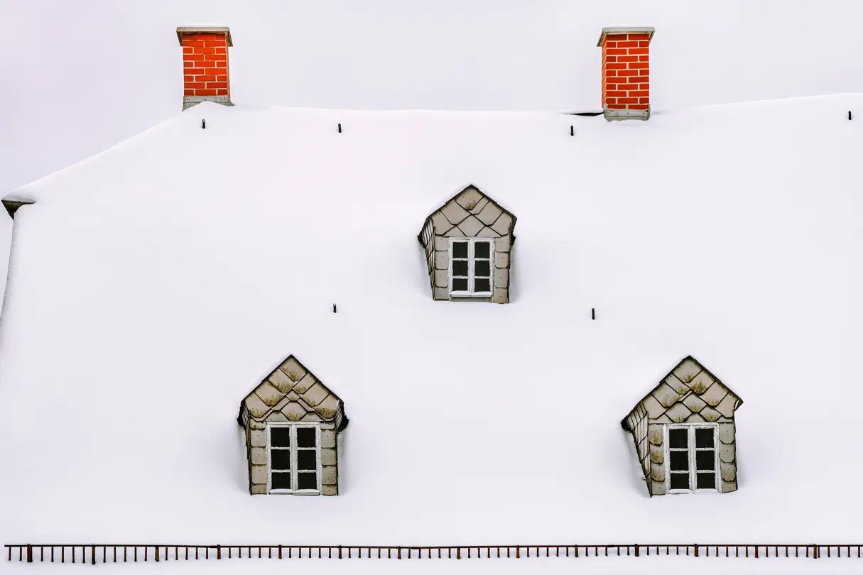 A snowed over roof of a house