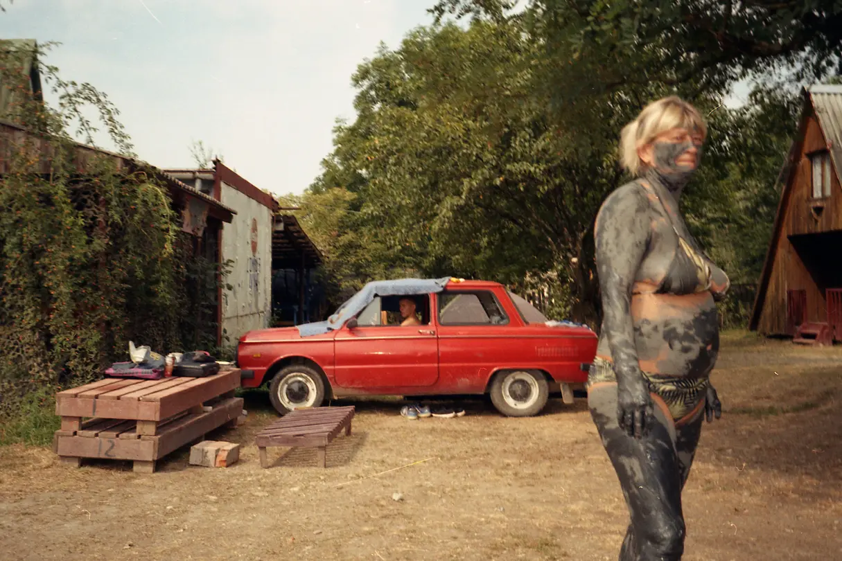A woman in front of a red car