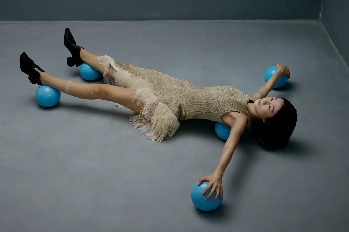 Woman lying on five small blue balls