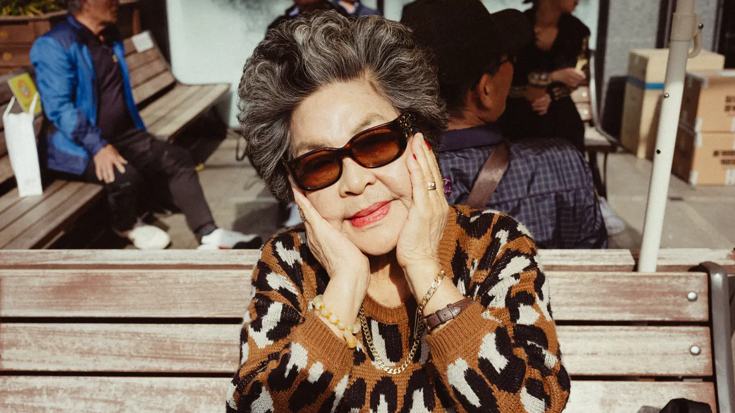 Personne avec des lunettes de soleil qui tient son visage dans ses mains
