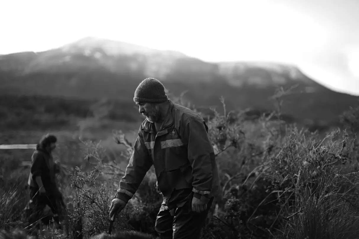Black and white photograph of a man working in a field in the countryside