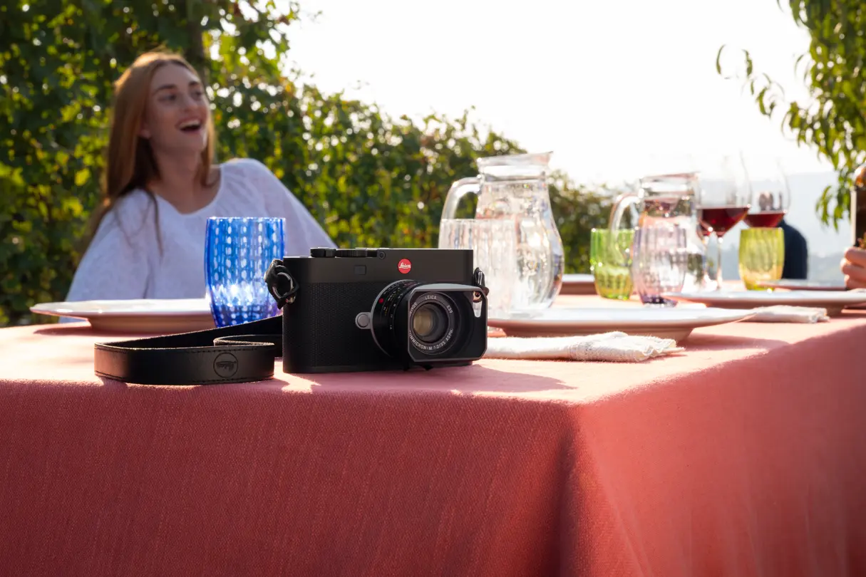 Table with woman in the vineyards, a Leica M camera in the foreground