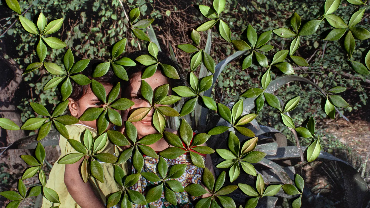 woman with her child behind leafs