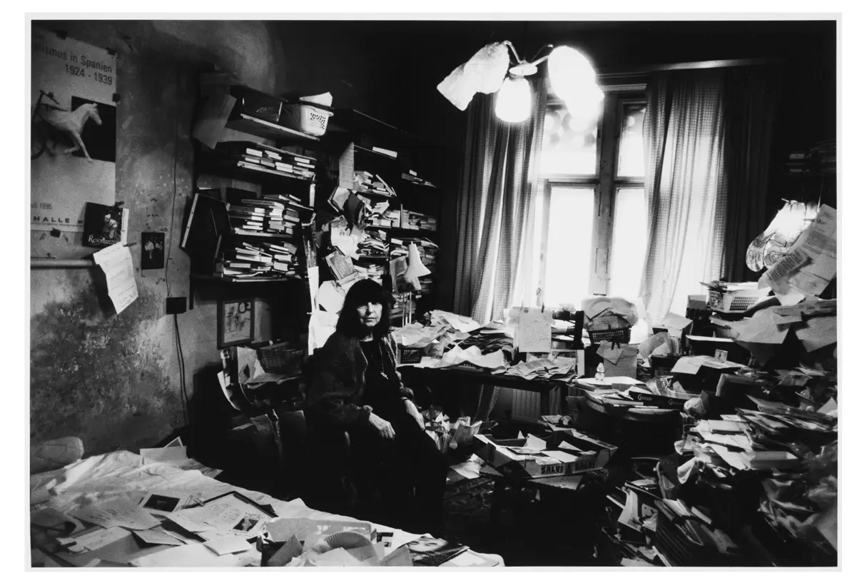 Woman sitting in an old room full of books and notes