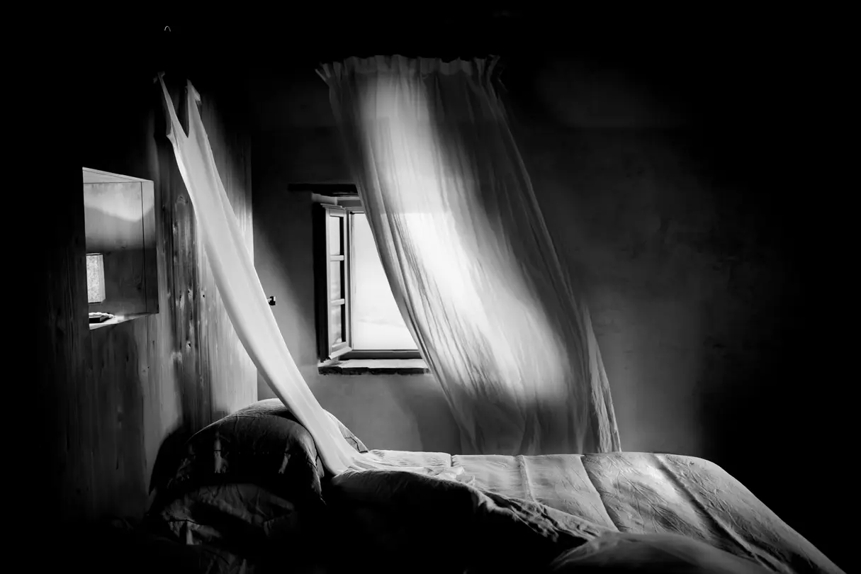 monochrom photography open window with a curtain in front of it