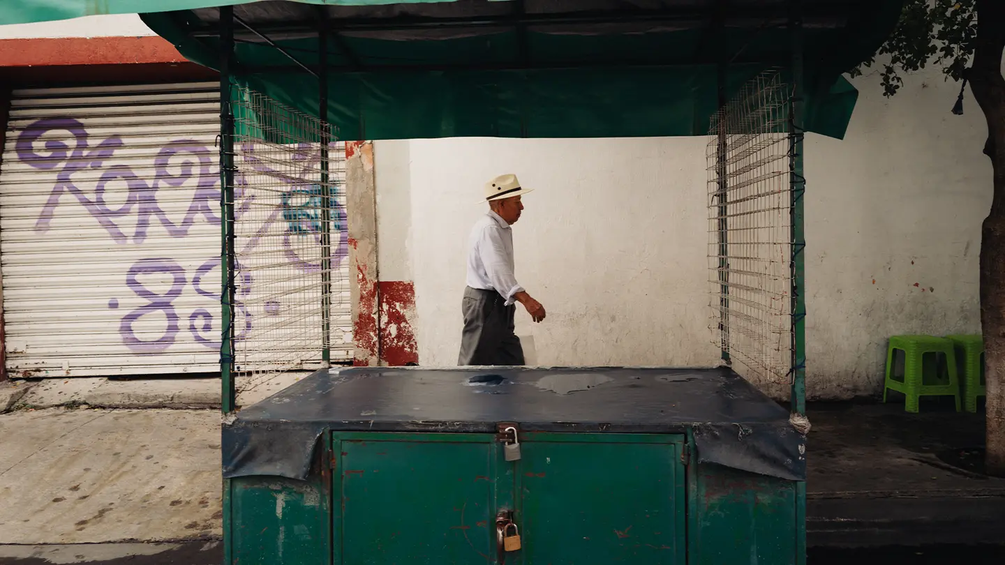 colour images of a man with white coat in market in Mexico.