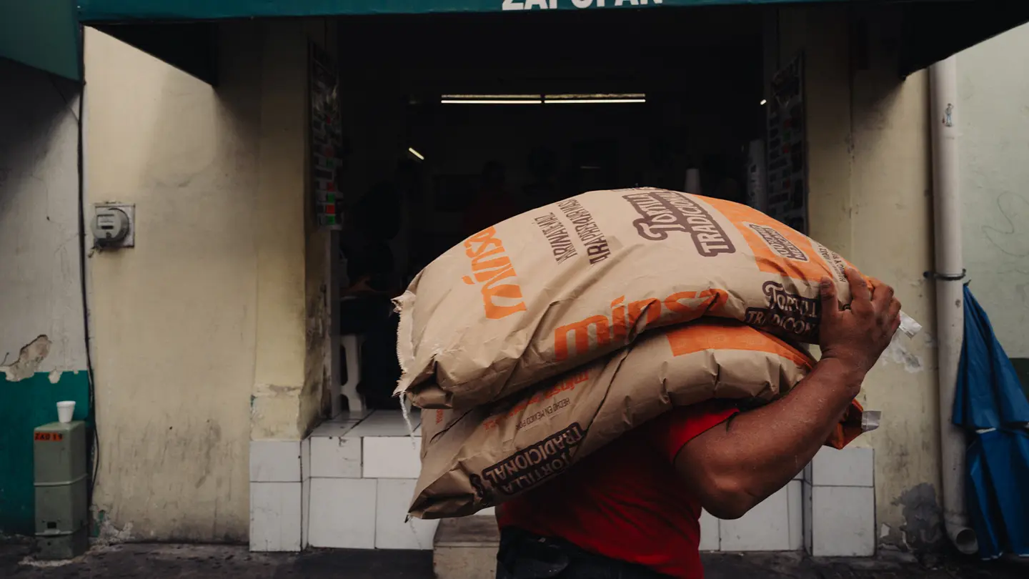 colour image of a man carrying sacks in a market in Mexico.