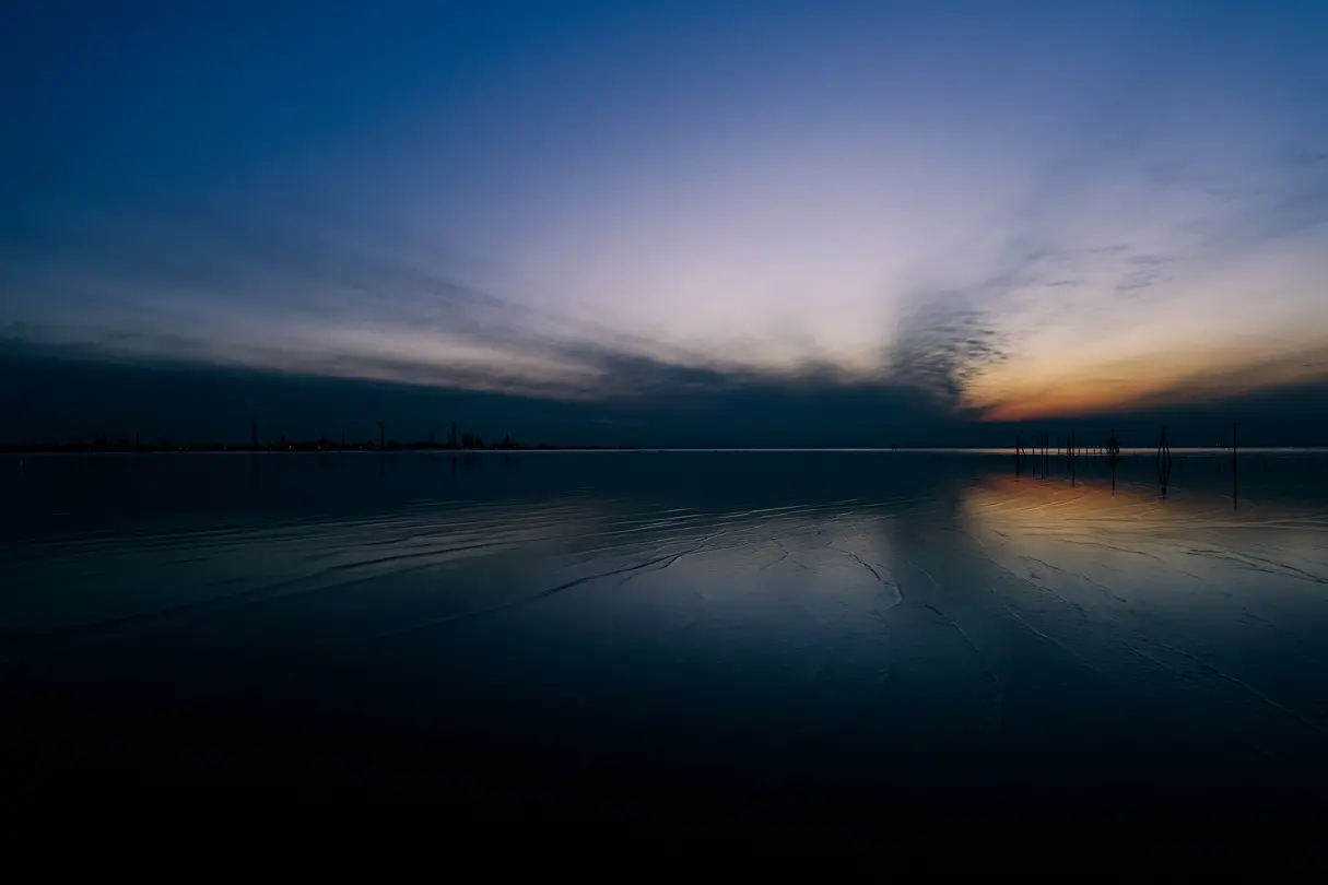 Blue sky at sunrise over a lake with a wooden pier