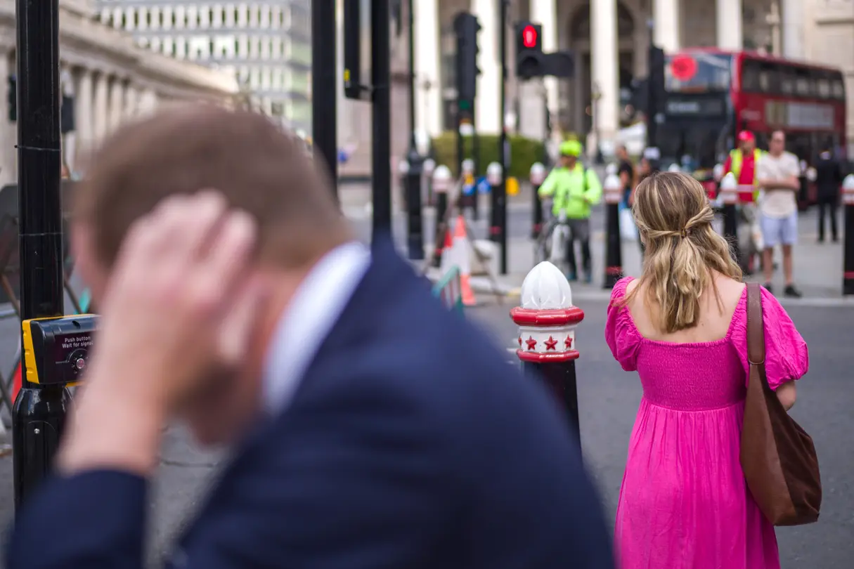 Woman in pink dress at a crossroads among many people in London