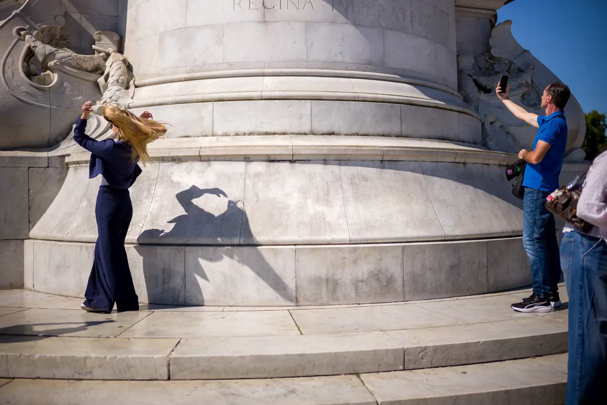 Two people photograph a large stone statue