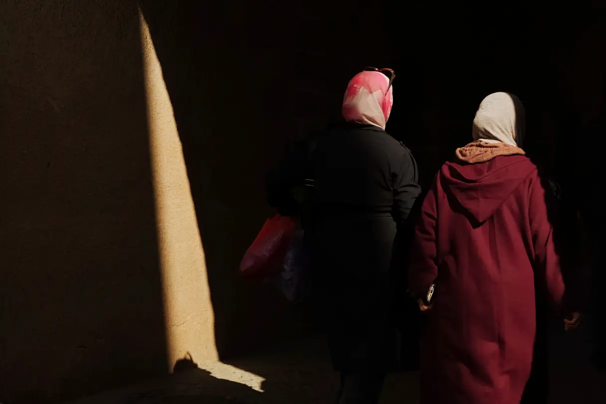 Two women photographed between shadows in the sun