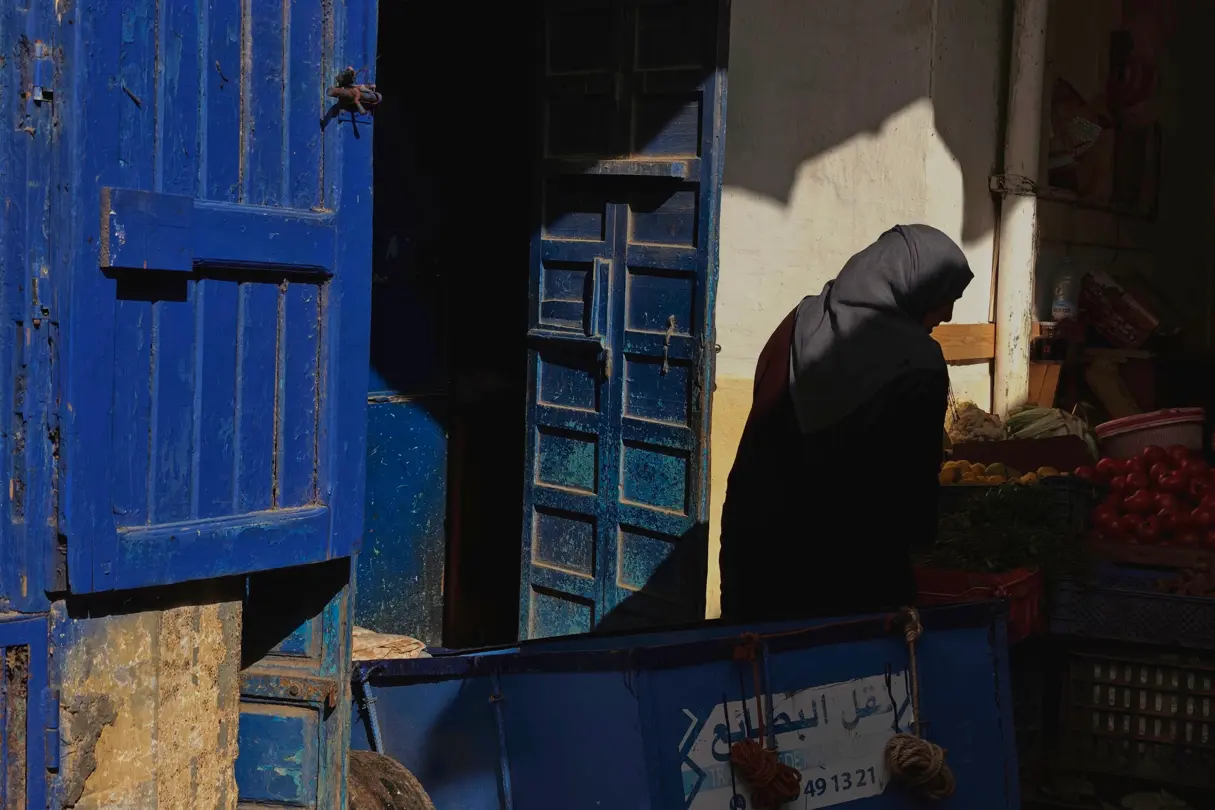 Old woman wearing a headscarf at a vegetable stall