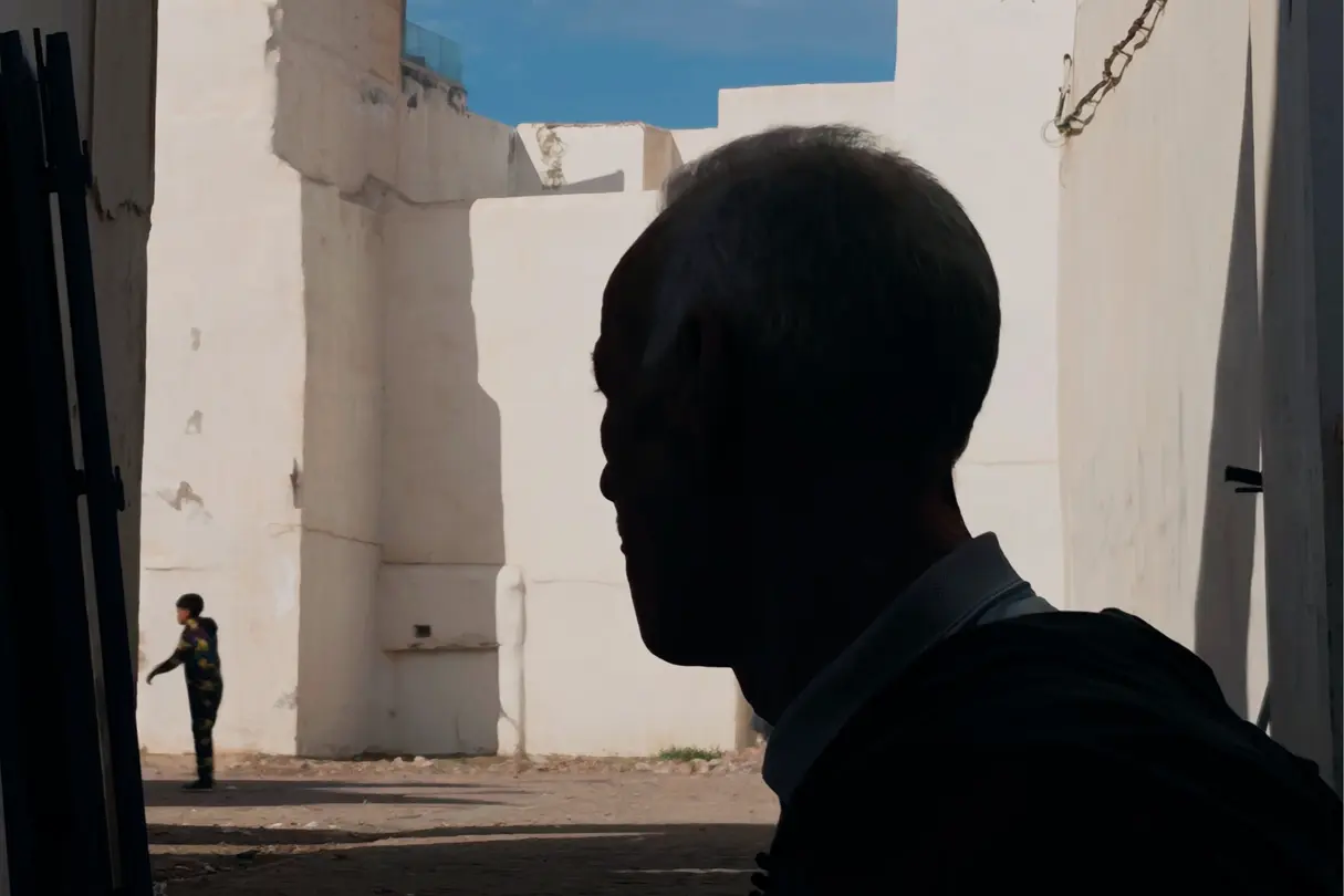 Close-up of a man in shadow with light background