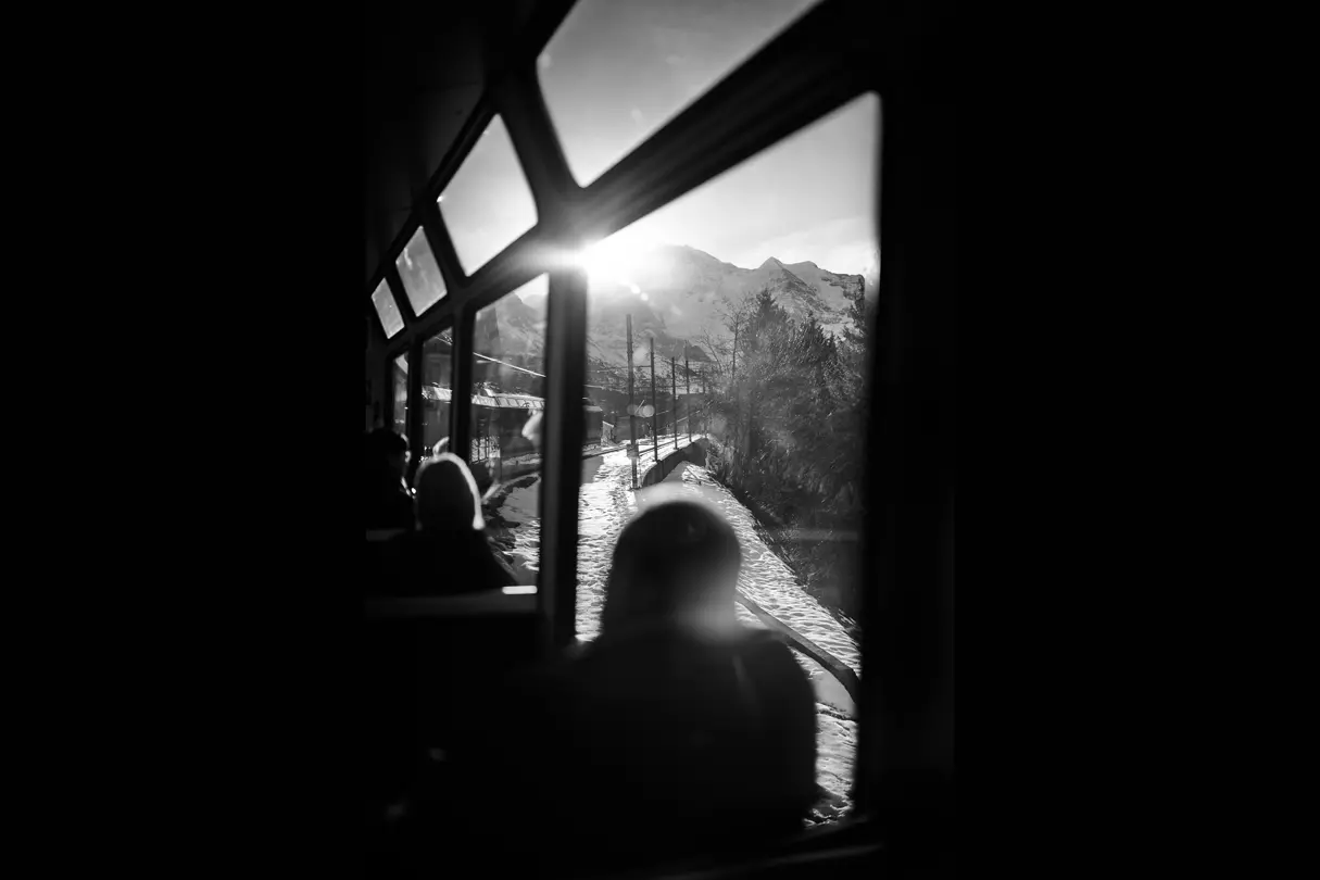 Black and white photo about a people watching out a train