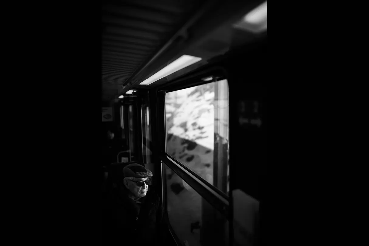 Black and white photo of an old man in a train