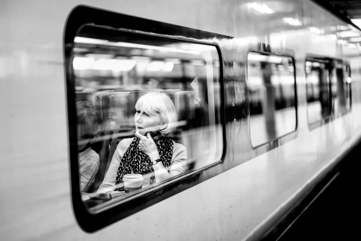 woman sitting in subway black and white