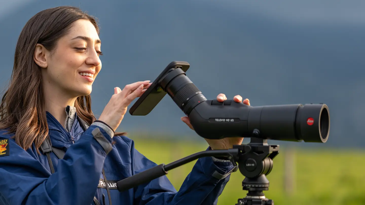 Woman is digiscoping with her Leica Televid and Smartphone