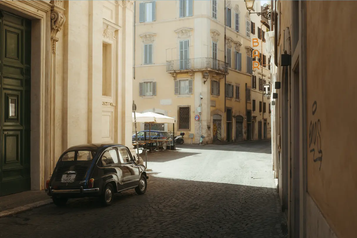 Sunlit historic street in a European city.