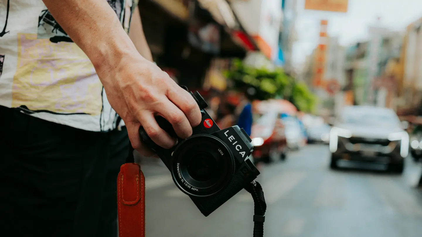 Person holding a Leica SL camera on an urban street