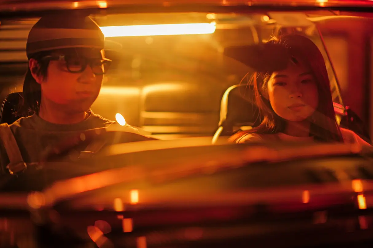 Night-time car scene with two people in warm light