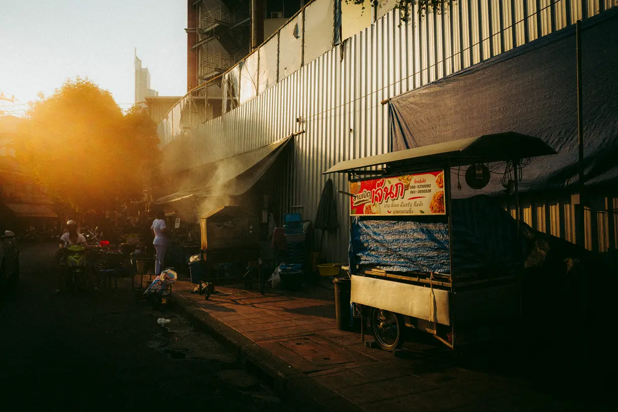 Urban street scene with steam rising and warm sunlight at sunset