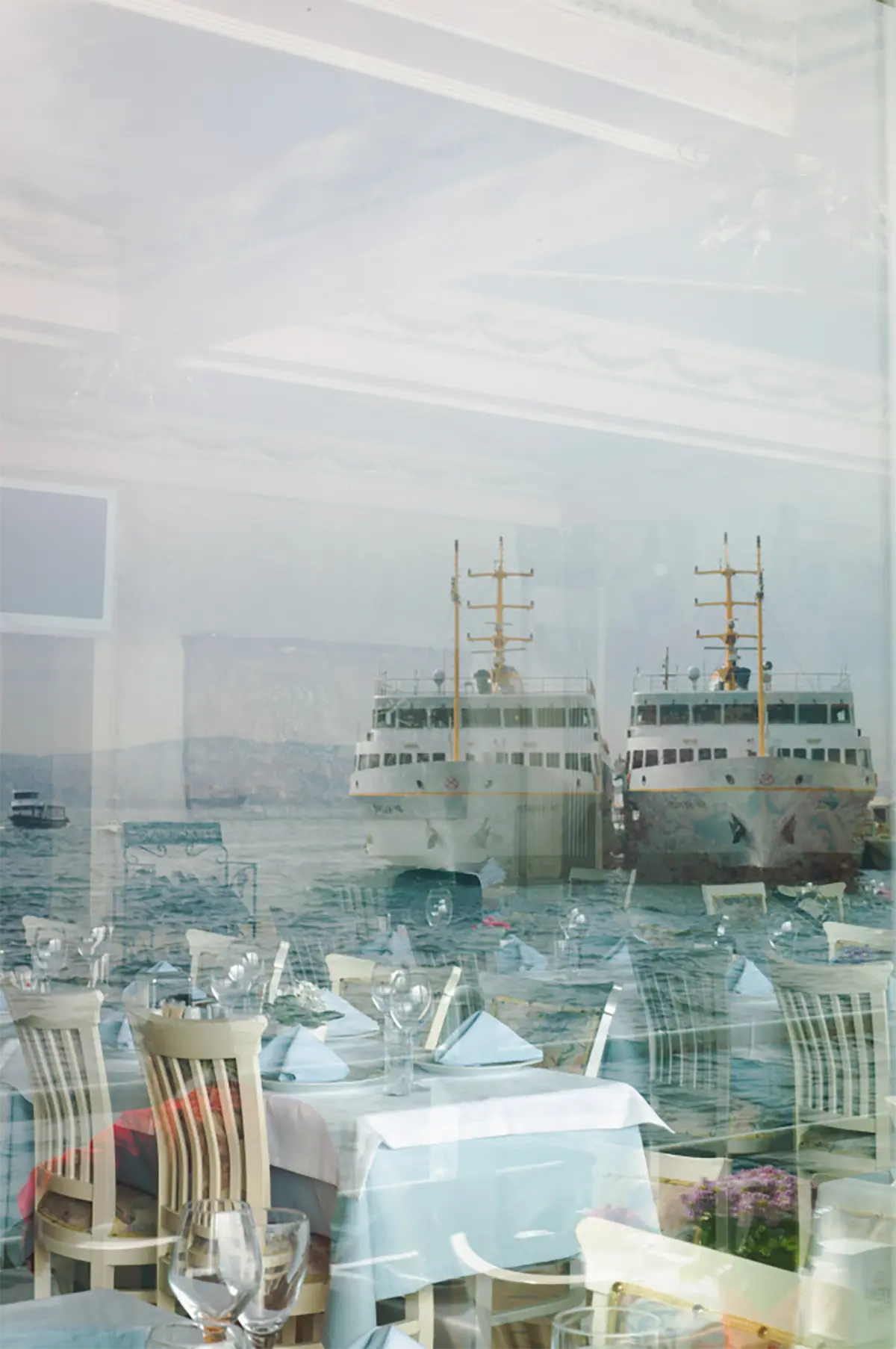 View through the restaurant window overlooking the sea and two large ships