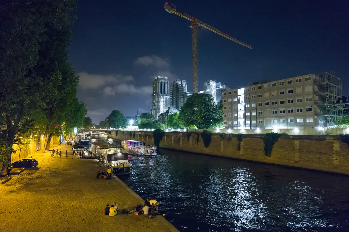 A town by the river at night, lit by street lamps