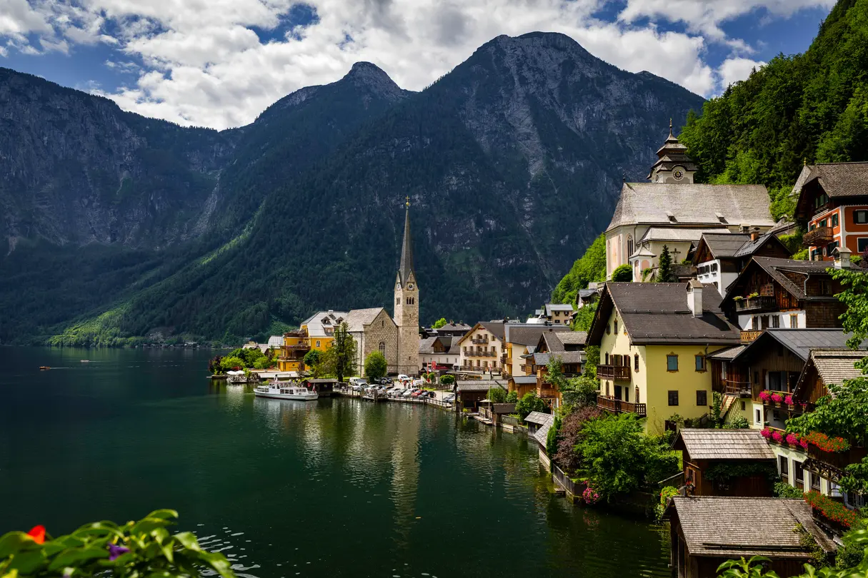 A small village with a church by a lake at the foot of a mountain