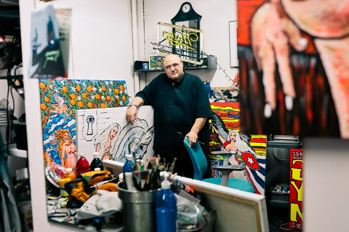 A painter among his paintings and painting supplies