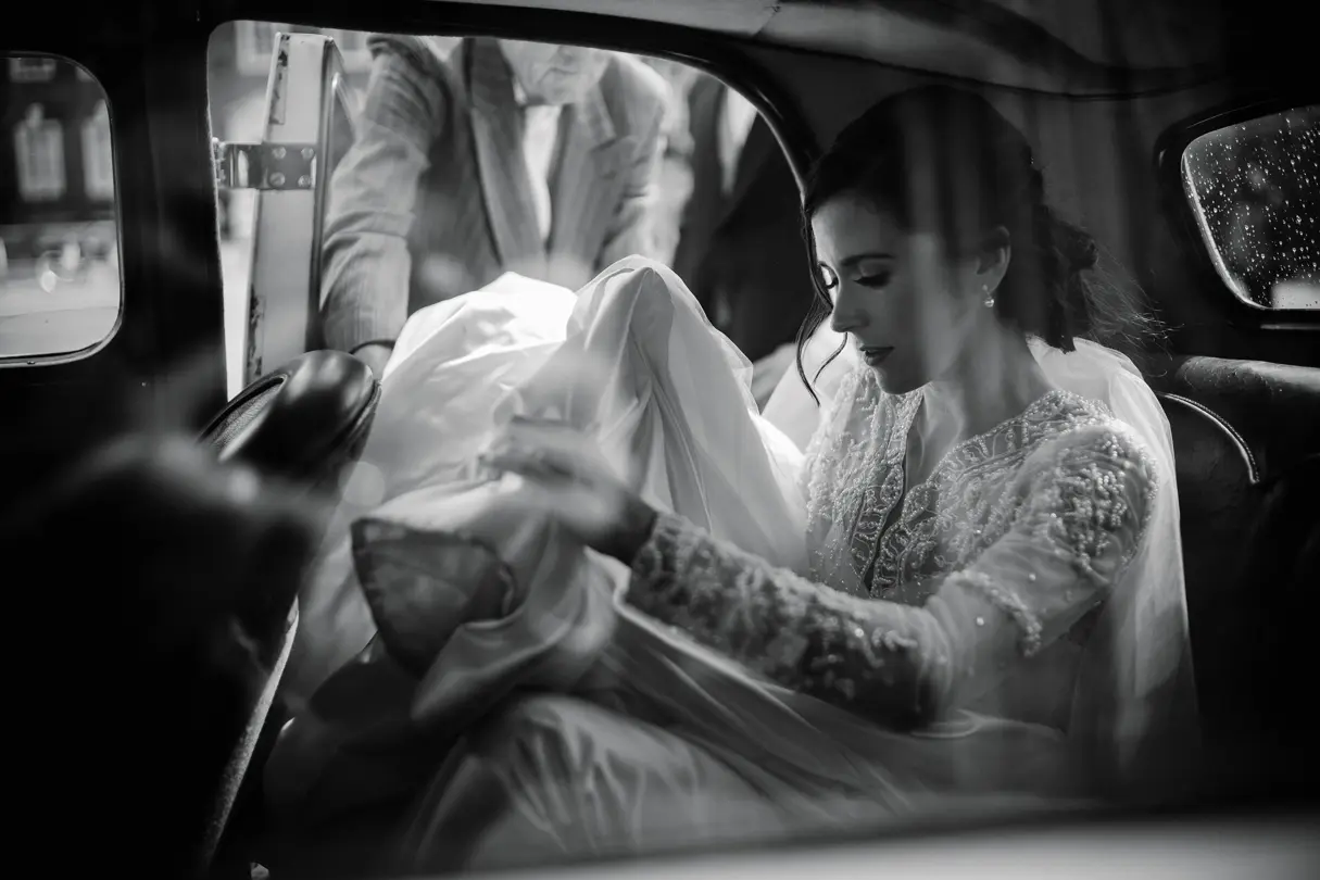 Black and white portrait of a bride in a car