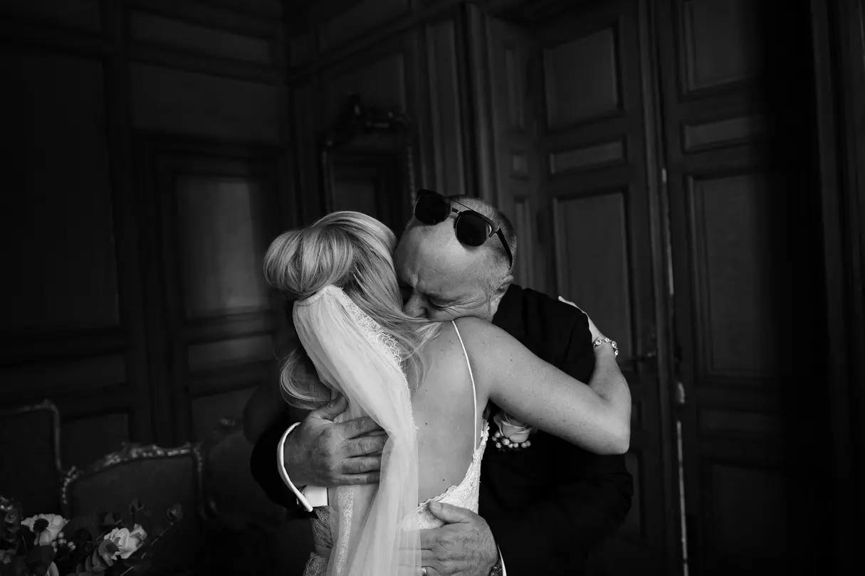 Black-and-white photo of a warm embrace between the bride and her father