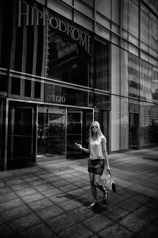 woman walking with phone b&w