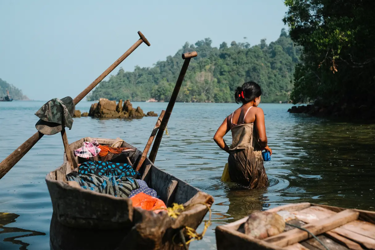 Personne qui marche dans l’eau à côté d’une barque