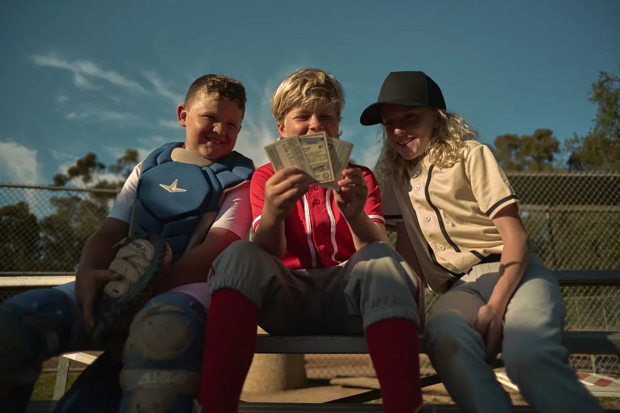 Three boys are looking at baseball cards