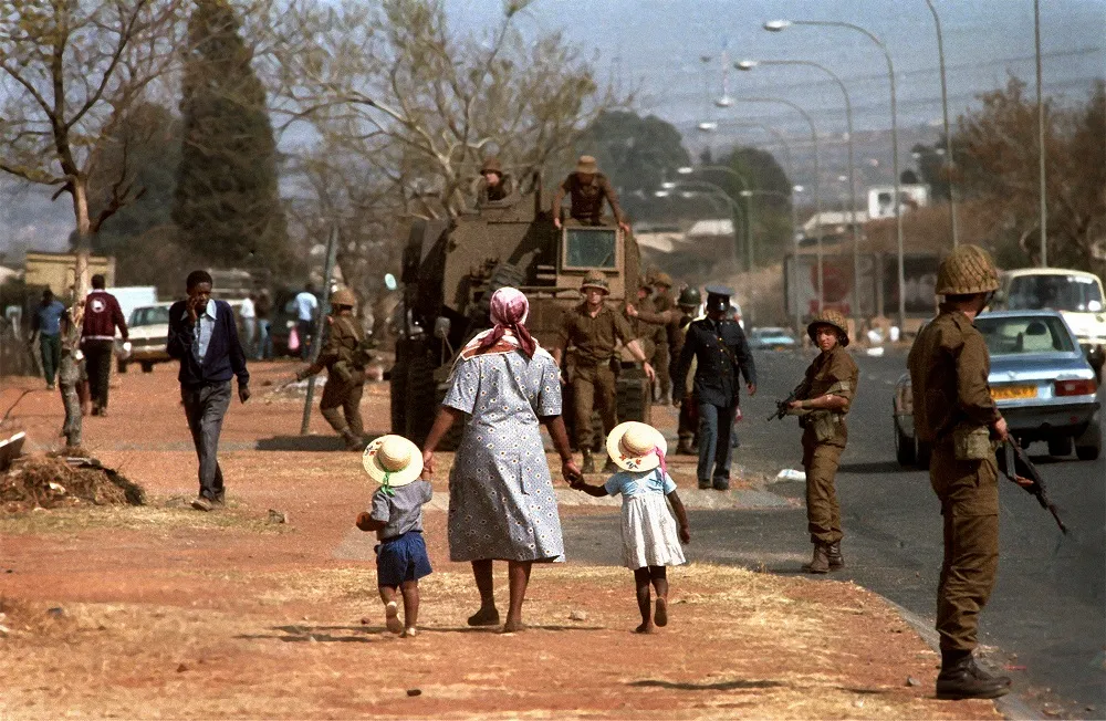 family walking, army in background
