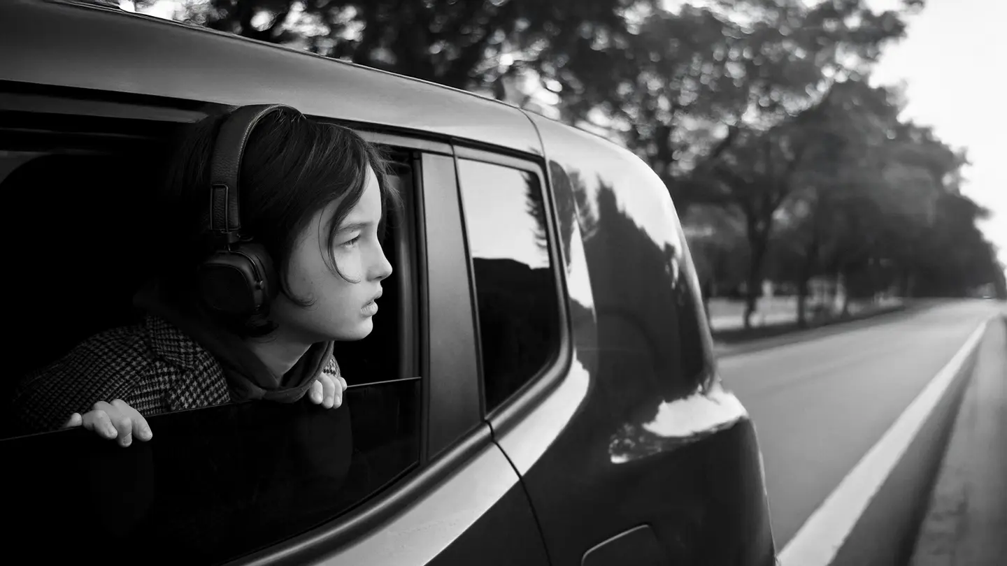 black-and-white photograph, a girl looking out of a moving car