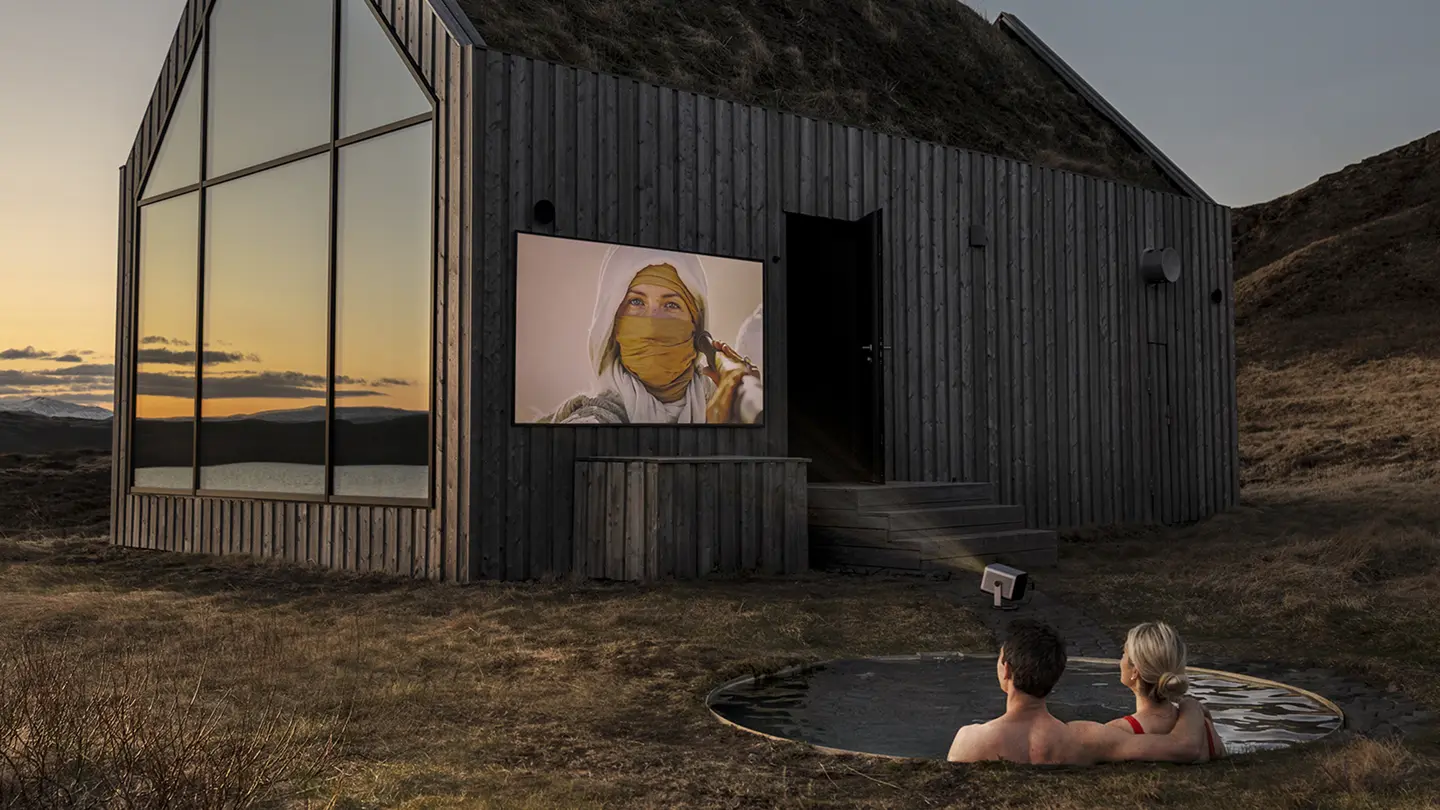 Couple using the Cine Compact 1 outside while sitting in a pool