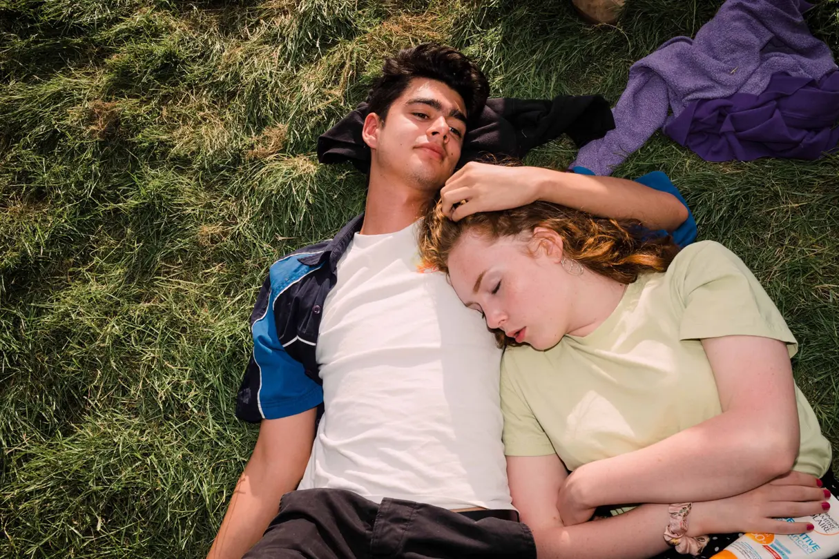 Couple cuddling while laying in the grass