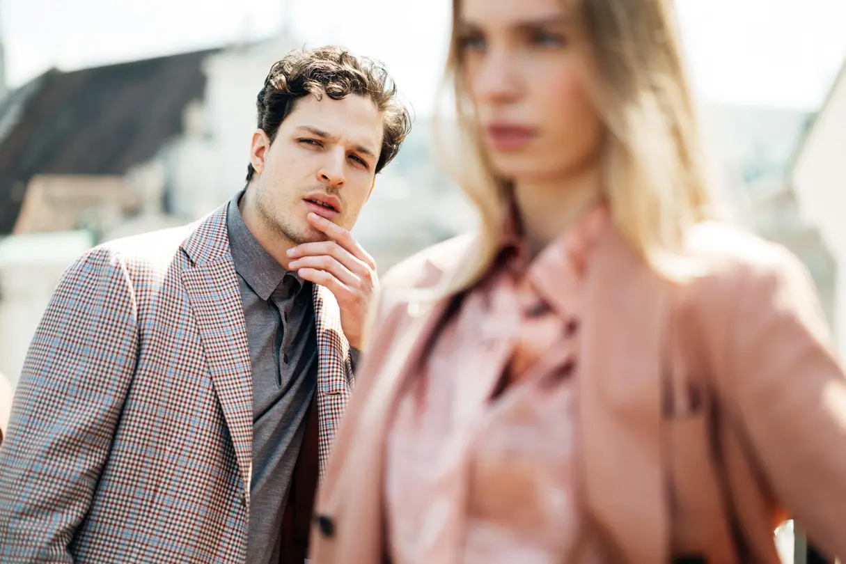 A man in a suit standing behind a young woman