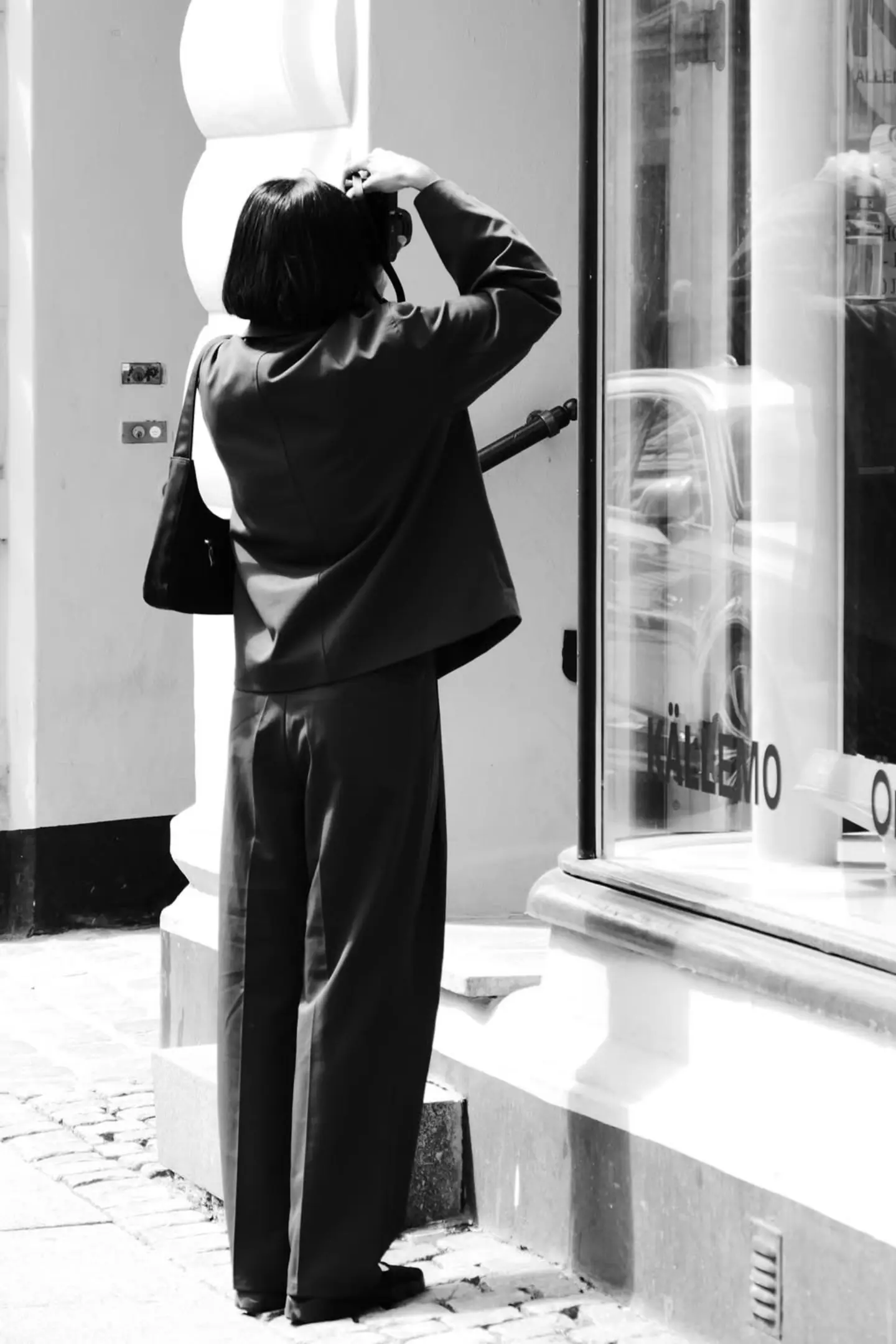 A woman is taking a photograph of a window
