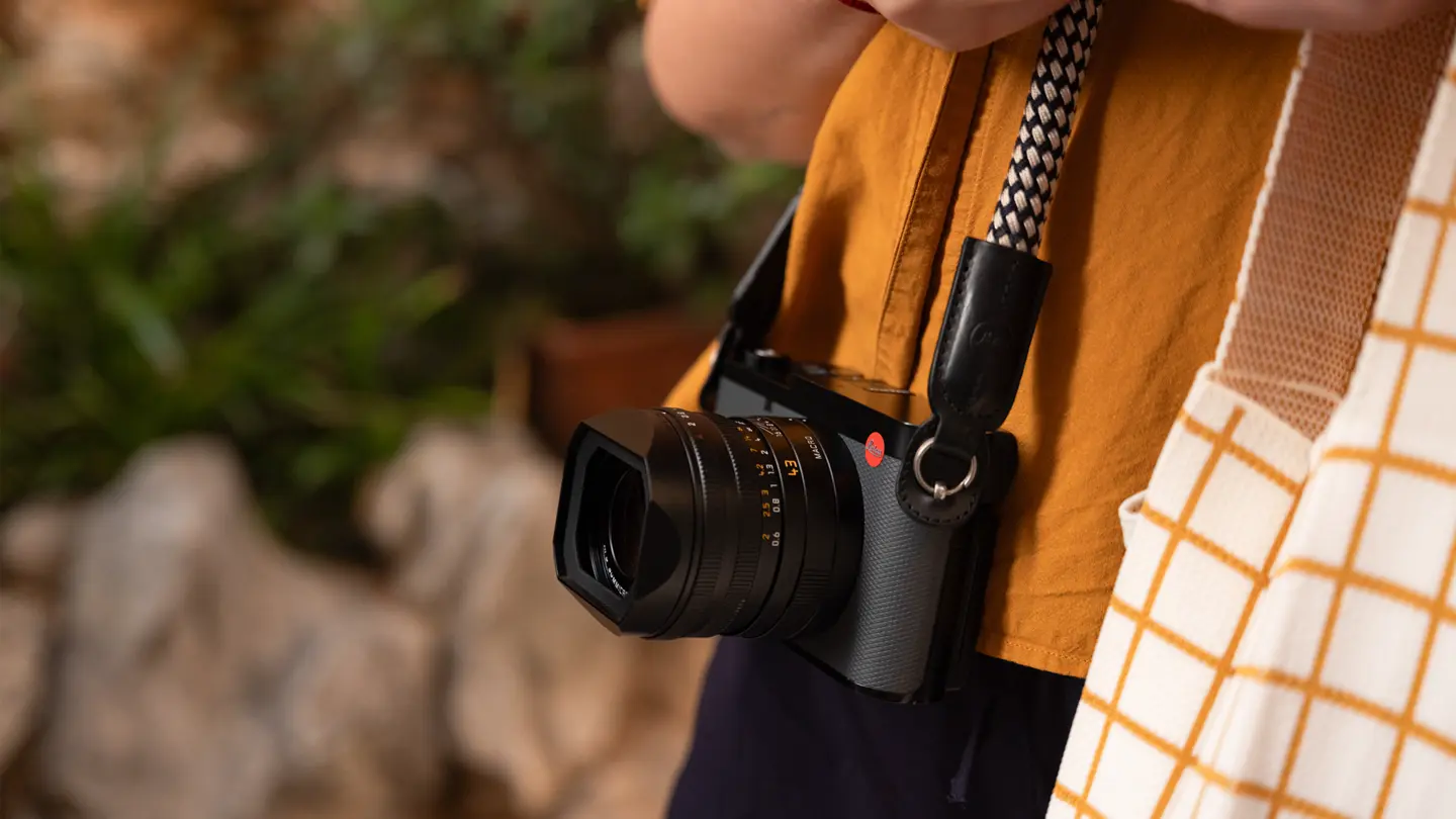 Person carrying a Leica camera while exploring outdoors