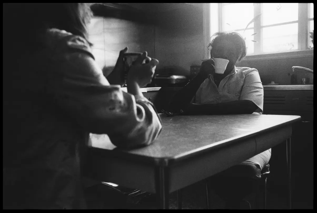 Cully sharing coffee at her kitchen table in Arkansas. Black-and-white analog photograph from Lisa McCord’s long-term documentary series exploring family life and community.
