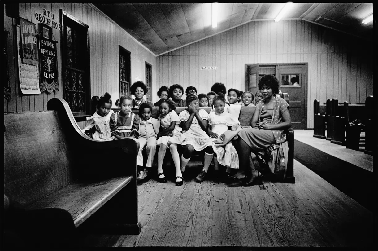 Children and families gathered for Sunday school in a rural Arkansas church. Black-and-white analog photograph from Lisa McCord’s documentary series on faith, family, and community life.