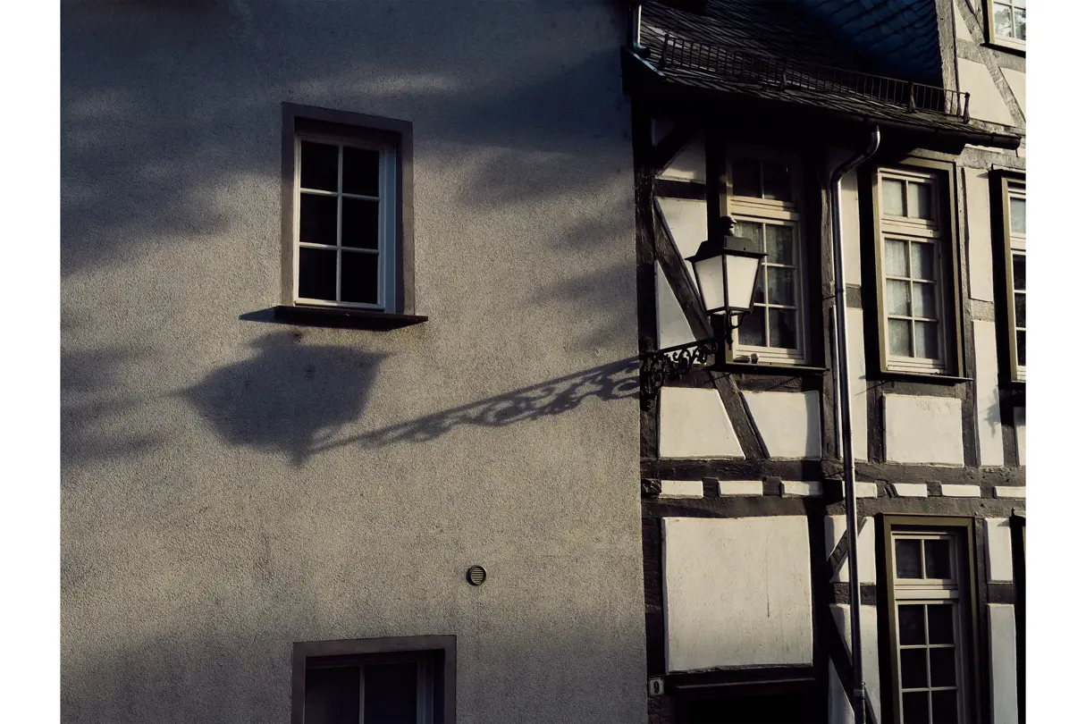 Historic streetscape with half-timbered architecture and dramatic shadows, showcasing European urban character.