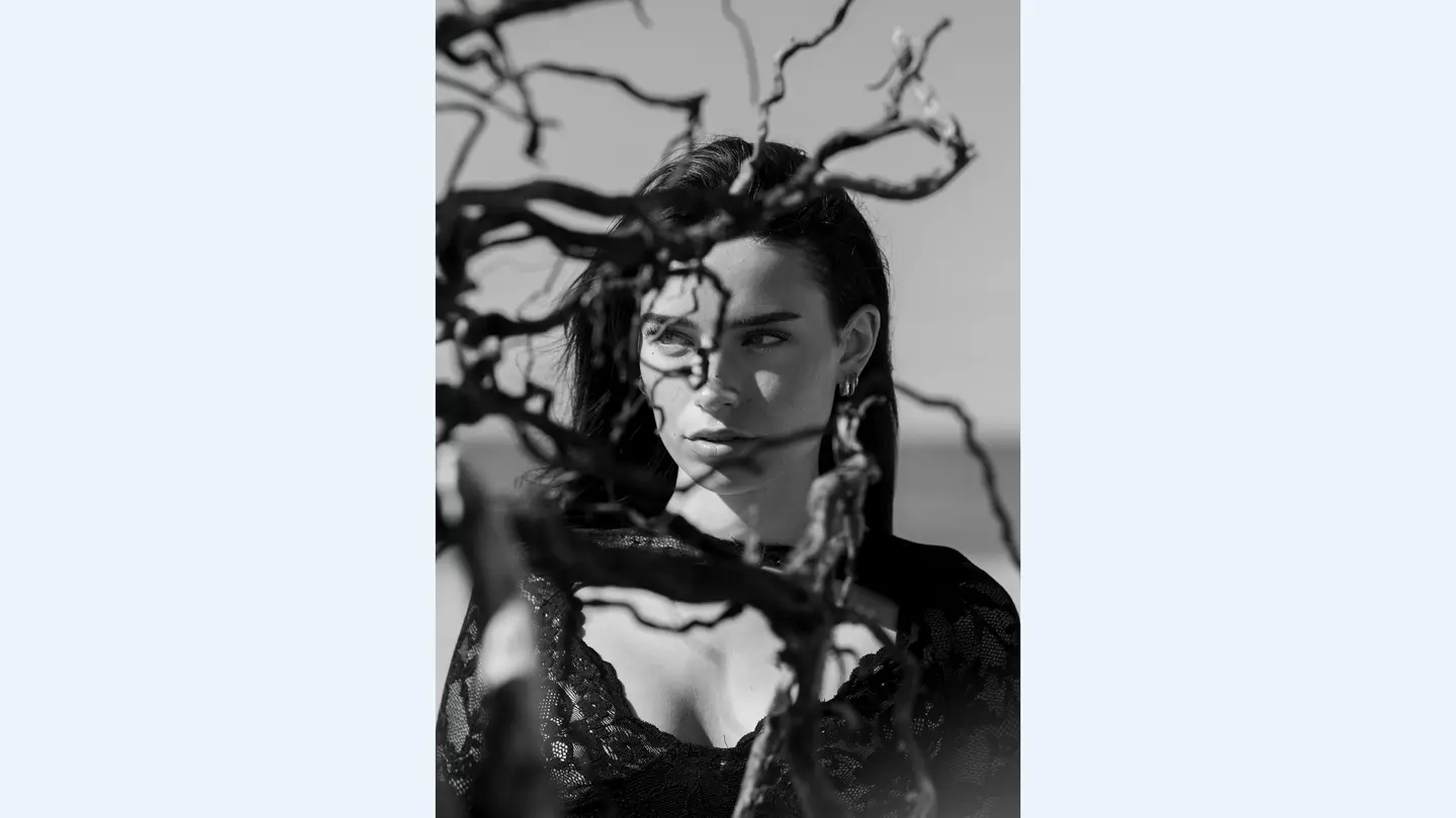 Portrait d'une femme derrière les branches d'un arbre